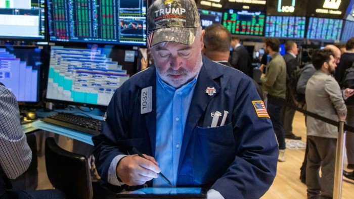 A trader wearing a Trump hat works on the floor of the New York Stock Exchange