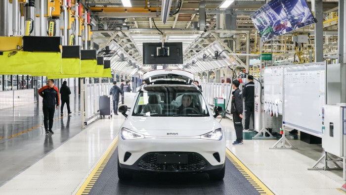 Employees work on the assembly line of Smart electric vehicles (EVs) at Geely’s Automotive Manufacturing Base in China