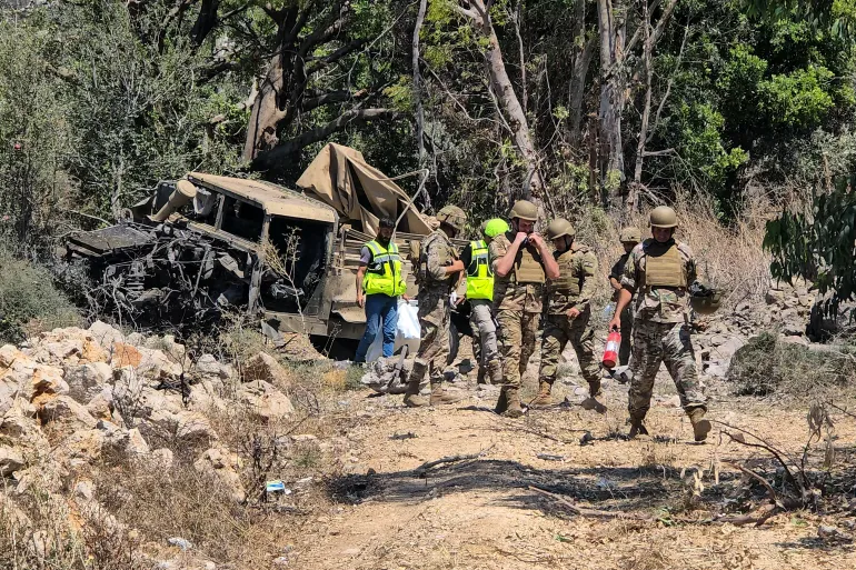 جنود من الجيش اللبناني يتفقدون موقع انفجار استهدف سيارتهم في منطقة المنصوري بجنوب لبنان بالقرب من صور في 18 يوليو 2026.