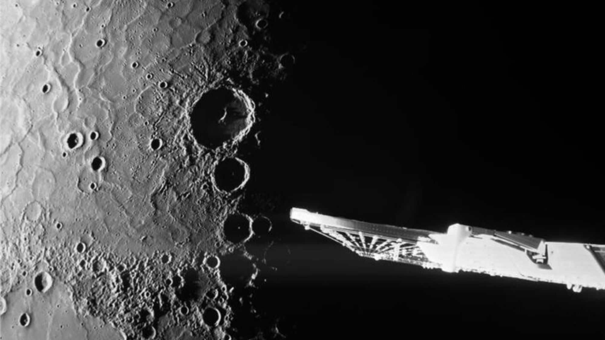 الحفر العميقة التي تظهر على كوكب في هذه الصورة بالأبيض والأسود. يظهر جناح شمسي على الجانب الأيمن.