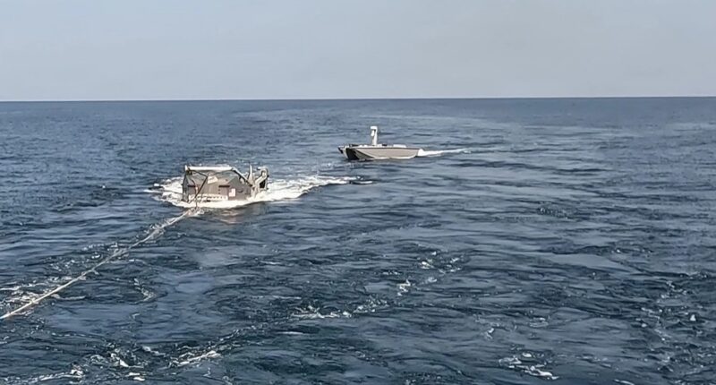 روبوت يزوّد قاربًا مسيّرًا بالوقود في عرض البحر خلال اختبار للبحرية الأمريكية